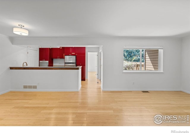 kitchen featuring oven, stainless steel refrigerator, and light hardwood / wood-style floors