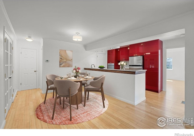 dining room featuring ornamental molding and light hardwood / wood-style floors