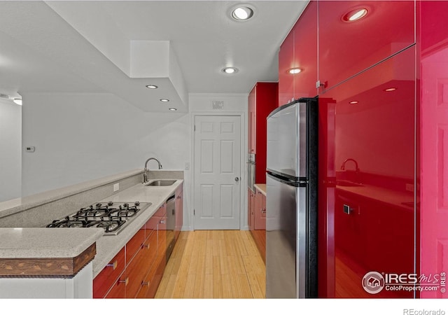 kitchen featuring appliances with stainless steel finishes, sink, and light hardwood / wood-style flooring