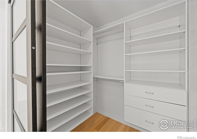 spacious closet featuring light hardwood / wood-style flooring