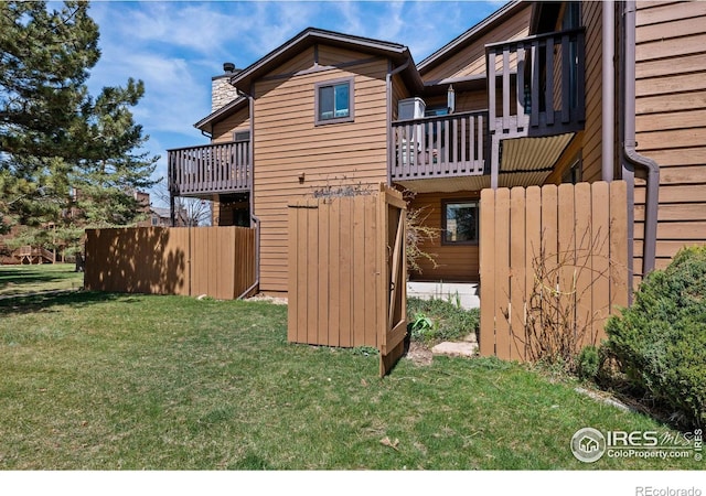 view of side of property with a yard and a balcony