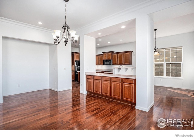 kitchen with pendant lighting, dark hardwood / wood-style flooring, crown molding, and a notable chandelier