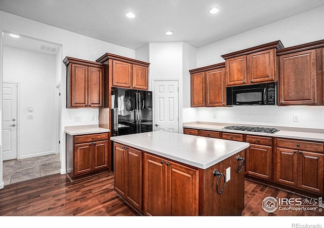 kitchen with black appliances, dark hardwood / wood-style floors, and a center island