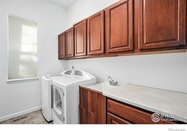 clothes washing area with light tile patterned floors, cabinets, washer and dryer, and sink