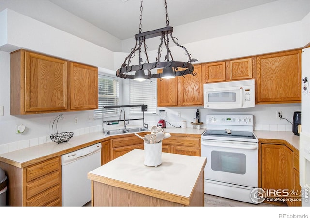 kitchen with hanging light fixtures, sink, white appliances, and a center island