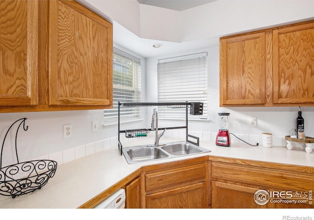 kitchen with a sink, brown cabinetry, and light countertops
