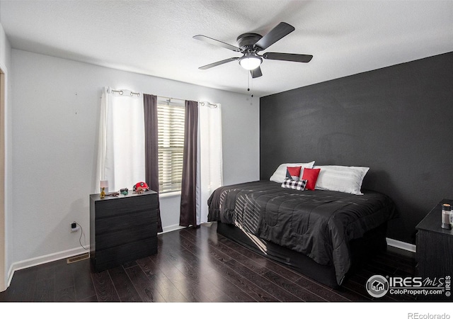 bedroom with dark wood-type flooring, a textured ceiling, and ceiling fan