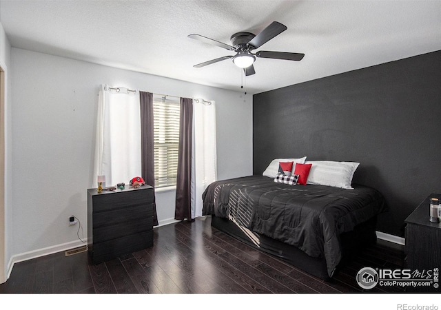 bedroom featuring visible vents, baseboards, a ceiling fan, and wood finished floors