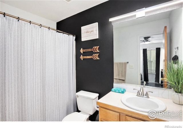 bathroom featuring walk in shower, ceiling fan, vanity, and toilet