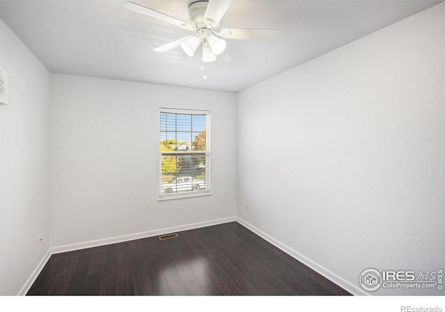 unfurnished room featuring a ceiling fan, baseboards, dark wood-style floors, and visible vents