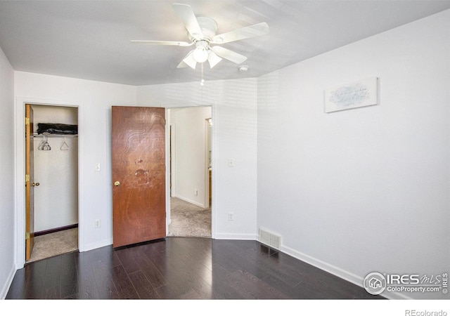 unfurnished bedroom with a closet, dark hardwood / wood-style floors, and ceiling fan