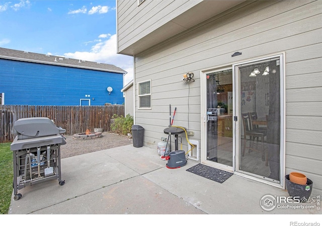 view of patio / terrace with an outdoor fire pit, fence, and grilling area