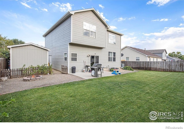 back of property featuring a patio area, a fenced backyard, a fire pit, and a lawn