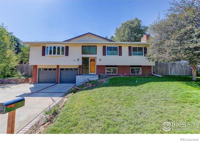 raised ranch featuring a garage and a front lawn