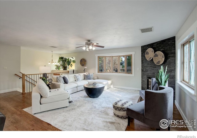 living room with a large fireplace, plenty of natural light, and hardwood / wood-style flooring