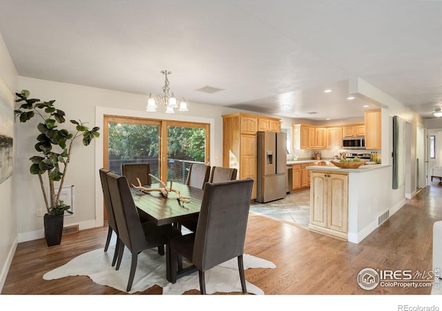 dining space featuring a notable chandelier and light hardwood / wood-style flooring