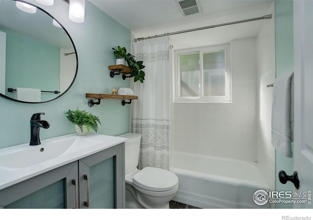 full bathroom featuring vanity, shower / bath combo with shower curtain, and toilet