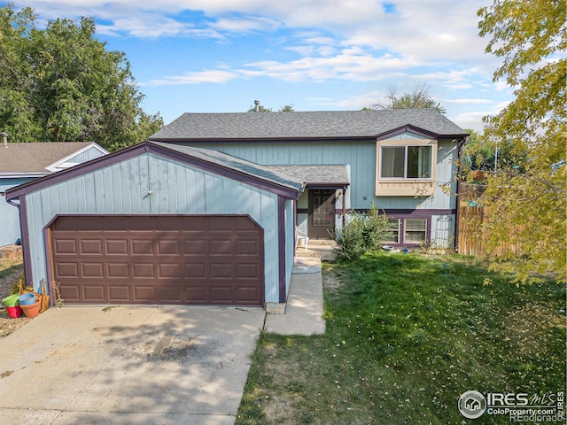 1900 Logan St, Longmont, CO 80501 - view of front facade with fence, an attached garage, concrete driveway, roof with shingles, and a front lawn