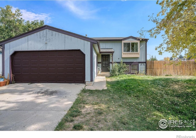 1900 Logan St, Longmont, CO 80501 - split level home with an attached garage, driveway, fence, and a front lawn