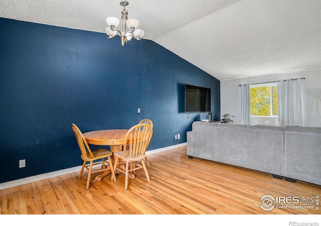 1900 Logan St, Longmont, CO 80501 - dining space featuring lofted ceiling, a textured ceiling, baseboards, an inviting chandelier, and wood finished floors