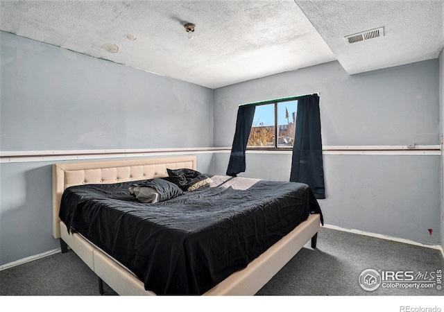 bedroom with carpet floors and a textured ceiling