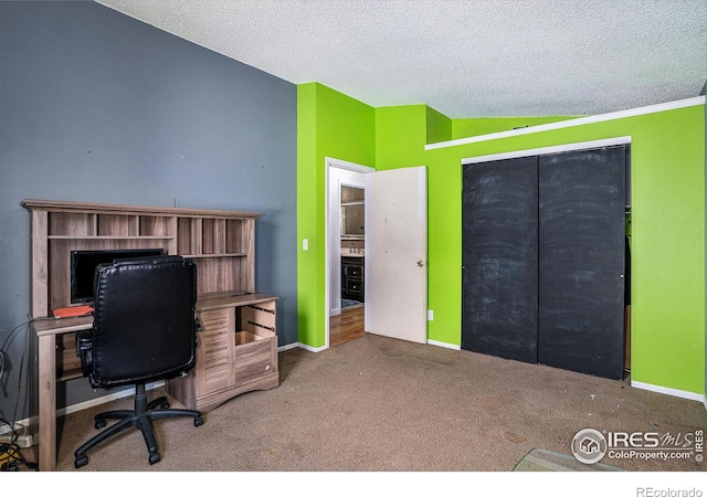 office with lofted ceiling, carpet flooring, and a textured ceiling