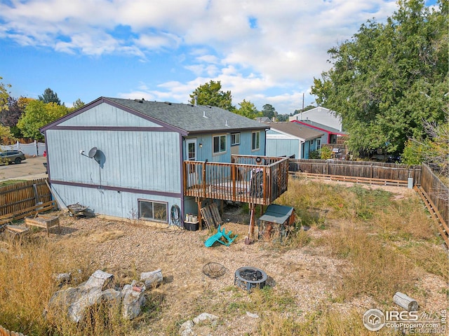 rear view of house featuring a fire pit and a deck