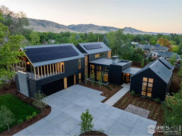 view of front of home with a mountain view, a garage, and solar panels