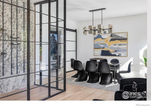 dining room with a wall of windows, a chandelier, and wood-type flooring