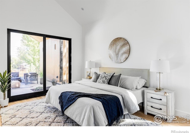 bedroom featuring light wood-type flooring, access to exterior, and high vaulted ceiling