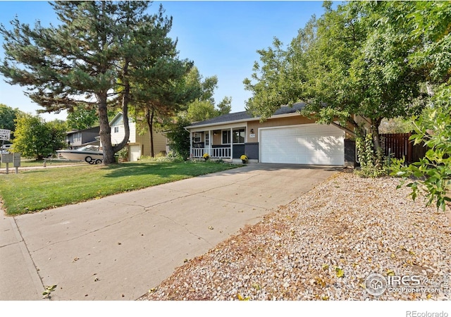 view of front of home with a front lawn, covered porch, and a garage