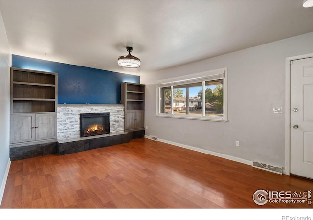 unfurnished living room with wood-type flooring and a fireplace