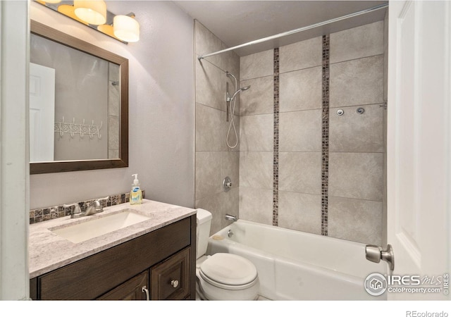 full bathroom featuring vanity, toilet, and tiled shower / bath