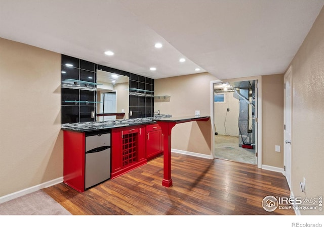 kitchen with stainless steel fridge and dark wood-type flooring