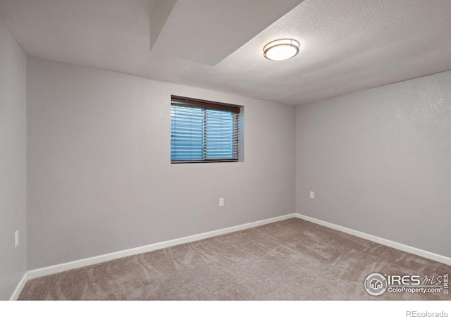 carpeted spare room with a textured ceiling