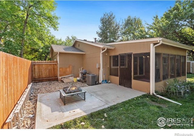 back of house featuring cooling unit, a fire pit, a sunroom, and a patio area