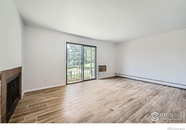 unfurnished living room featuring baseboard heating and light wood-type flooring