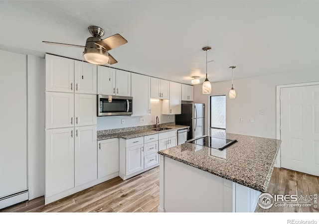 kitchen with a kitchen island, white cabinets, light hardwood / wood-style flooring, and stainless steel appliances