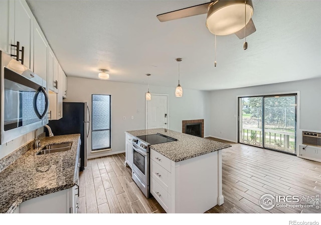 kitchen featuring appliances with stainless steel finishes, white cabinets, and dark stone counters