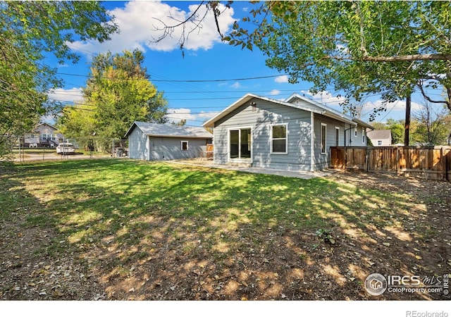 rear view of house featuring a patio and a yard