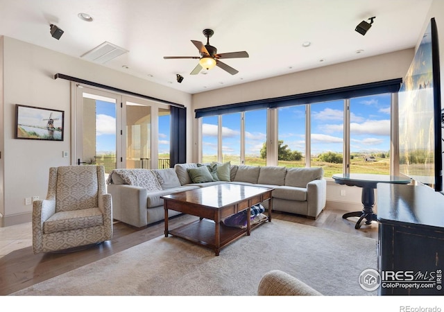 living area with wood finished floors, plenty of natural light, ceiling fan, and recessed lighting