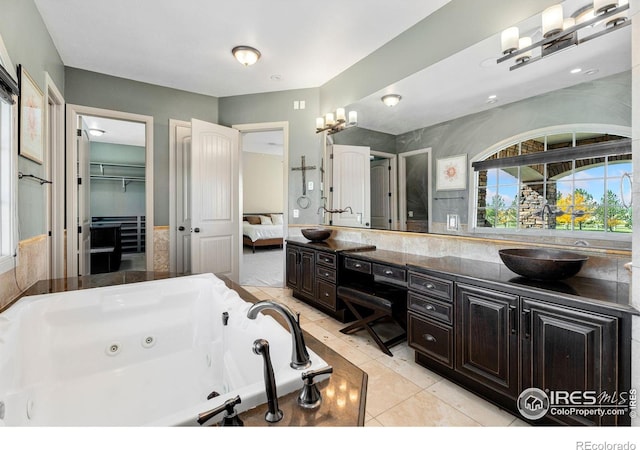 bathroom featuring vanity, a tub to relax in, and tile patterned floors