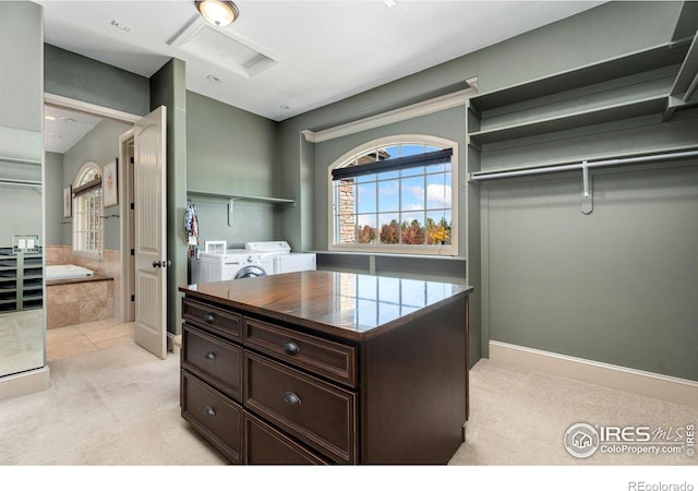 spacious closet with washing machine and dryer and light carpet