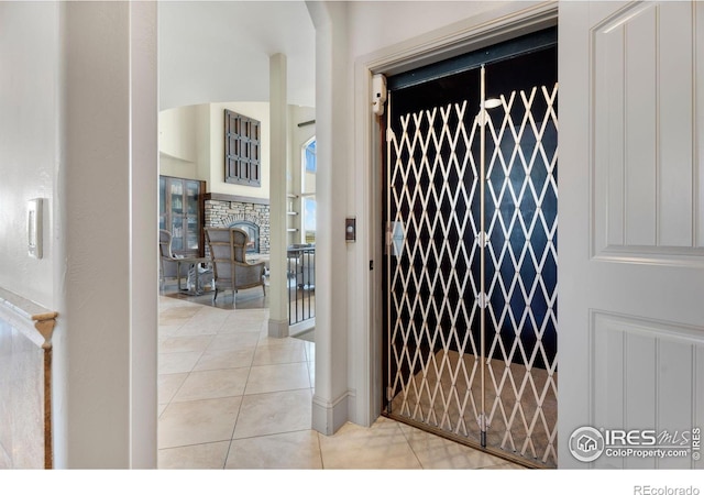 doorway to outside featuring light tile patterned floors and elevator