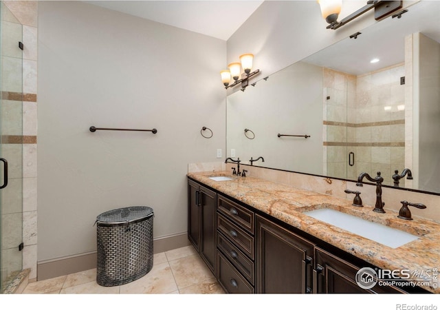 bathroom featuring a shower stall, double vanity, tile patterned flooring, and baseboards