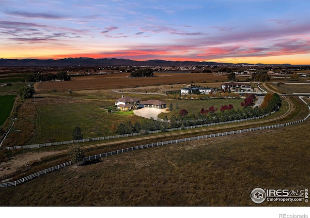 aerial view at dusk with a mountain view and a rural view