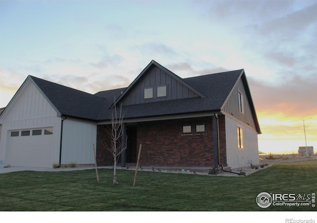 modern farmhouse style home featuring a yard and a garage