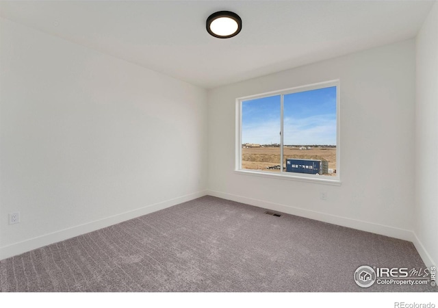 carpeted empty room featuring visible vents and baseboards