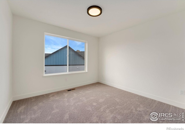 spare room with visible vents, baseboards, and carpet floors