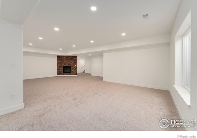 unfurnished living room featuring visible vents, carpet floors, baseboards, a fireplace, and recessed lighting